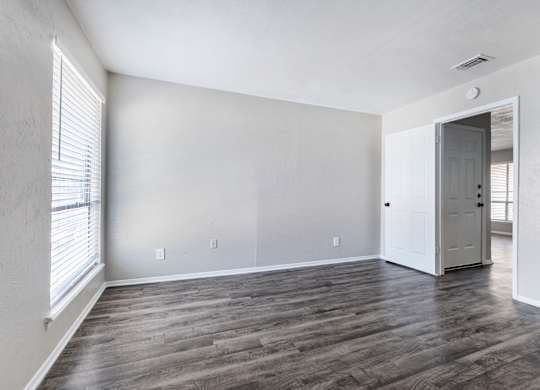 Spacious living room with window and hardwood flooring at Ridgeview Apartments, Sherman, 75092