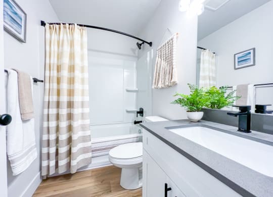 upstairs guest bathroom with full tub/shower, hotel rods, luxury vinyl plank flooring