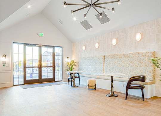 A white room with a wooden floor and a white wall with a patterned wallpaper.