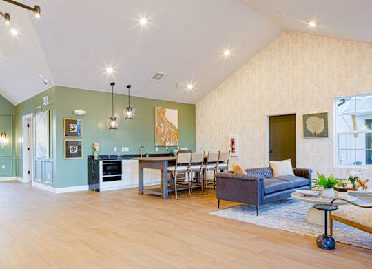 A modern living room with a kitchen area in the background.
