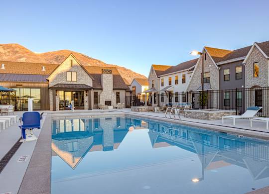 A large swimming pool in front of a resort.