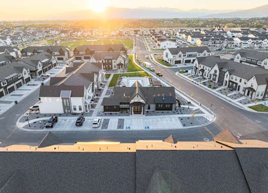 A sunset view of a residential area with houses and a roundabout.