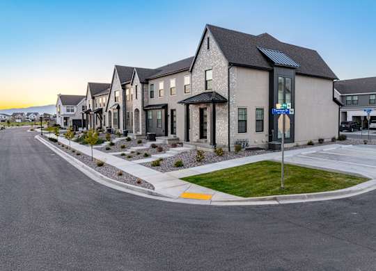 A row of houses with a street in front of them.