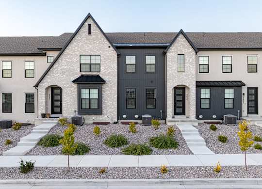 A row of houses with black front doors and windows.