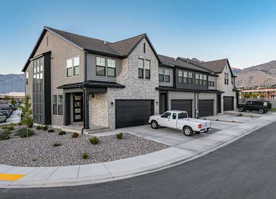 A modern house with a white pickup truck parked in front.