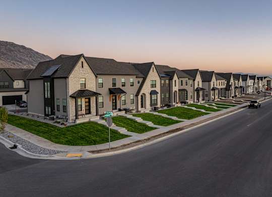 A row of houses with a street in front of them.
