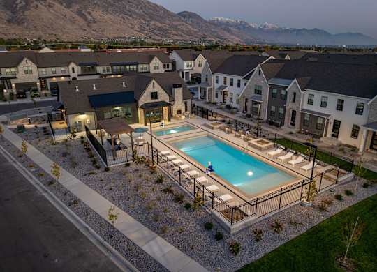 A swimming pool surrounded by a fence and a few chairs.