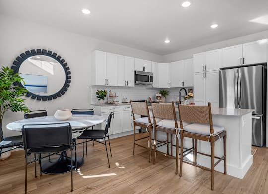 A modern kitchen with a dining table and chairs.