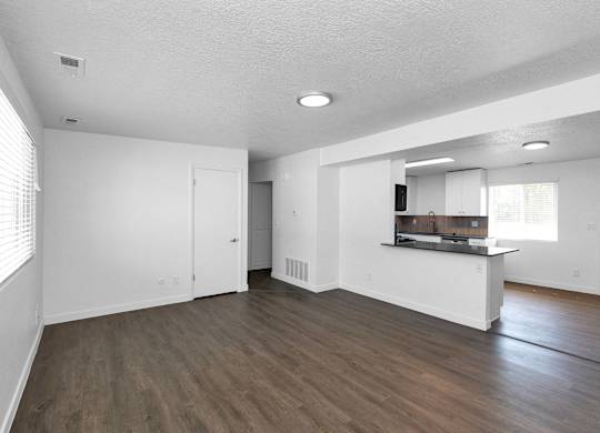 the living room and kitchen of an empty apartment