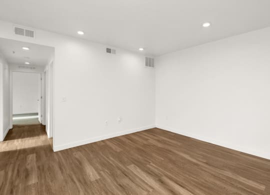 a living room with white walls and wood floors