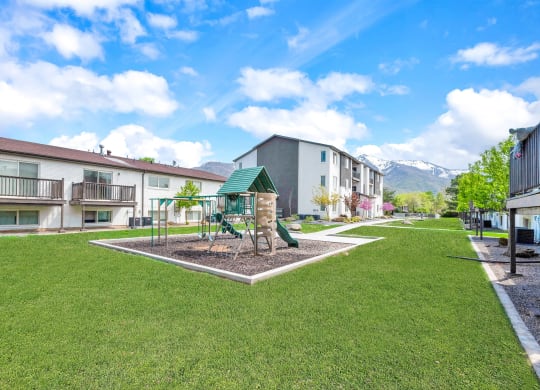a park with a playground in the middle of some apartments