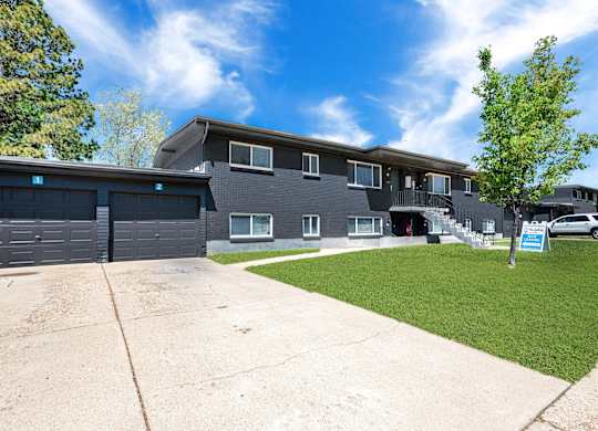 the front of a house with a driveway and garage doors