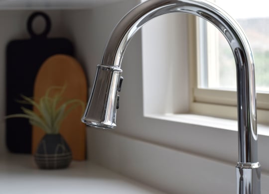 a kitchen sink with a faucet in front of a window