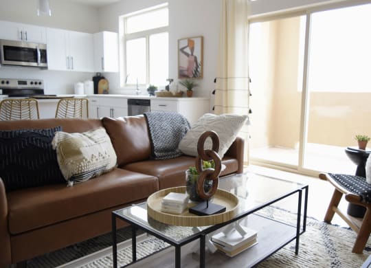 a living room with a brown couch and a coffee table with a sculpture on top of it
