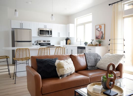 a living room with white walls and a brown leather couch