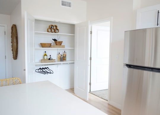 a kitchen with white walls and a stainless steel refrigerator