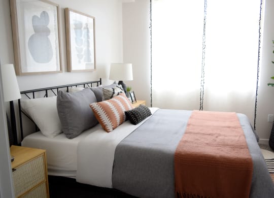 a bedroom with a bed and two paintings on the wall