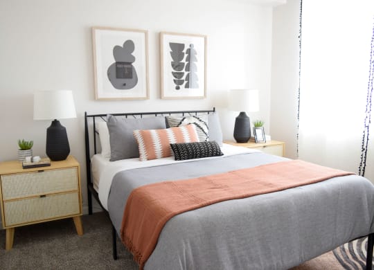 a bedroom with a bed and two night stands with lamps on them