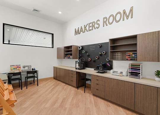 A makers room with a wooden floor and a white wall.
