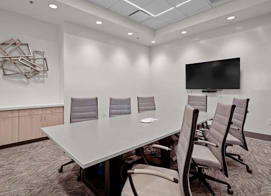 A conference room with a large table and chairs.