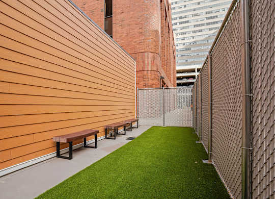 A long corridor with benches and a fence.