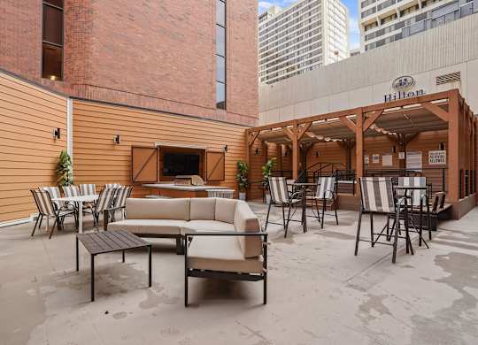 A patio with a couch, chairs, and a table.