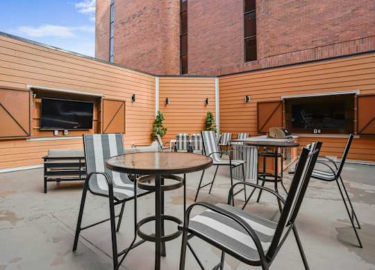 A patio with a table and chairs and a television.