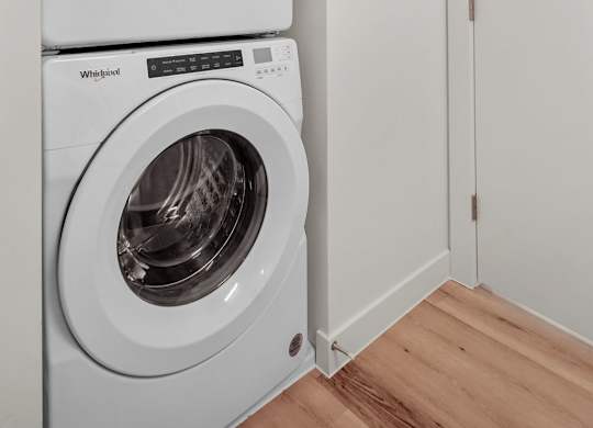 Two white washing machines stacked on top of each other.