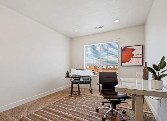 an office with a desk and chair and a window