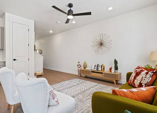 a living room with furniture and a ceiling fan