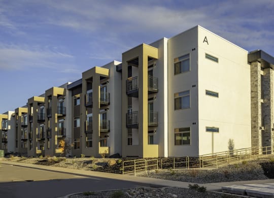 a row of modern apartments with balconies and a sky background