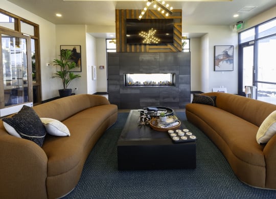 a living room with brown couches and a fireplace