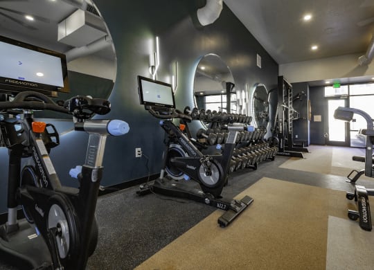 a gym with various exercise bikes and weights