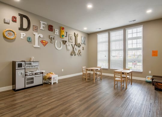 a playroom with a table and chairs and a stove