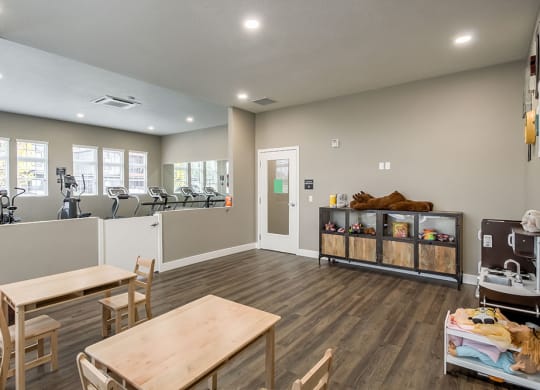 a fitness room with a table and chairs and a treadmill