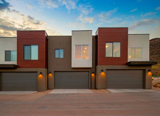 A modern house with a brown and beige exterior and a garage door.