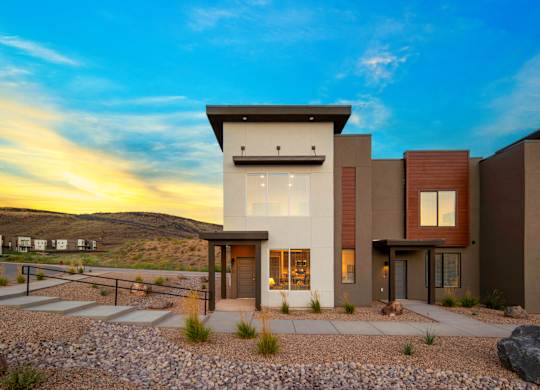 A modern house with a flat roof and a stone pathway leading to the entrance.