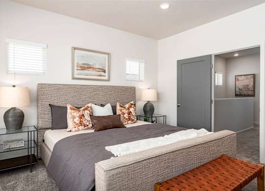 A bedroom with a large bed and a bench.