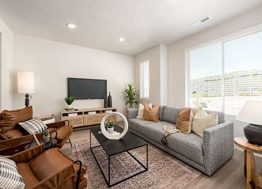 A living room with a grey couch, a coffee table, and a flat screen TV.