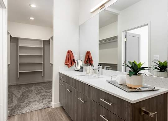 A bathroom with a sink, mirror, and towel rack.