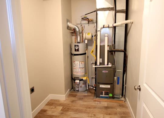 this is a picture of a basement with a water heater and a vacuum cleaner