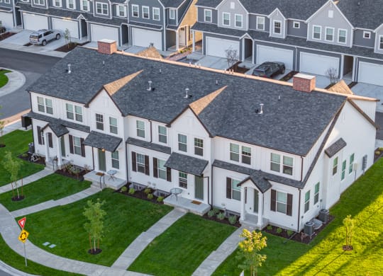an aerial view of townhomes with grass and 2-car garages