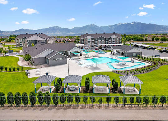 Affinity 56 Apartments for rent in West Jordan, UT  A resort with a pool and a mountain in the background.