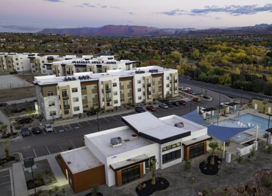 an aerial view of community with a pool and buildings