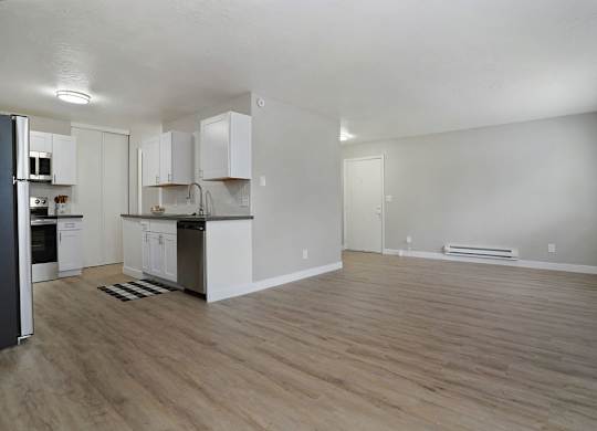 A kitchen with white cabinets and a refrigerator.