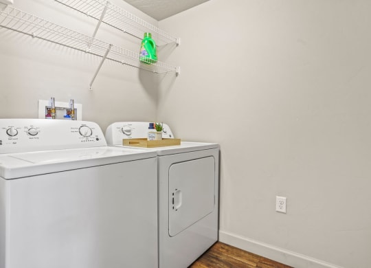 the laundry room has a washer and dryer and a rack on the wall