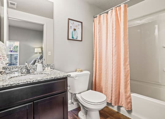a bathroom with a toilet and a shower and a sink