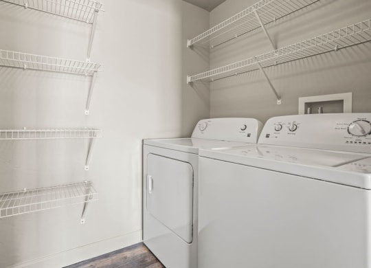 a laundry room with a washer and dryer and a closet with shelves