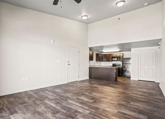 the living room and kitchen of a new home with white walls and wood flooring