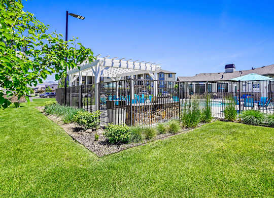 A backyard with a pool and a fence.